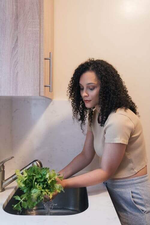 Woman washing vegetables